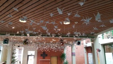 In leichter Luftbewegung schweben 1085 gefaltete weiße Kraniche aus Papier unter der Decke im Zentrum der Schule. Sie sollen ein Zeichen des Friedens sein.